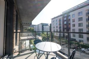 d'un balcon avec une table et une vue sur la rue. dans l'établissement Lumineux Appartement 1 chambre proche Ecole Européenne, à Bruxelles