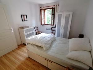 a bedroom with a bed and two chairs in it at Villa Lilas in Doumen