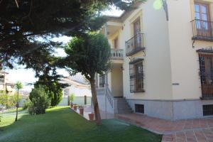a white house with a tree in the yard at Hotel La Zubia , Granada in La Zubia