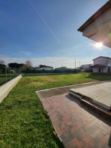 a brick walkway next to a field of grass at Alloggio indipendente Cesulìn in Porto Viro