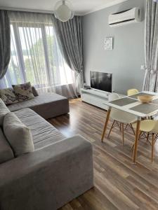 a living room with a couch and a table at Deluxe Apartments Приморско in Primorsko