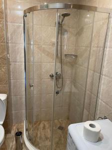 a shower stall in a bathroom with a toilet at Deluxe Apartments Приморско in Primorsko