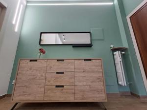 eine Holzkommode in einem Zimmer mit Spiegel in der Unterkunft Casa Mirò in Parma