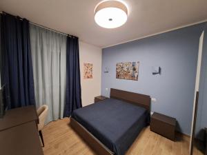 a bedroom with a blue bed and a window at Casa Mirò in Parma