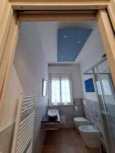 a bathroom with a sink and a toilet and a window at Casa Mirò in Parma