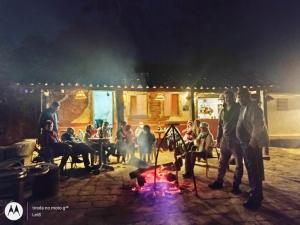 a group of people standing around a camp fire at Pouso do Tropeiro - Cavalgadas Roseta in Baependi