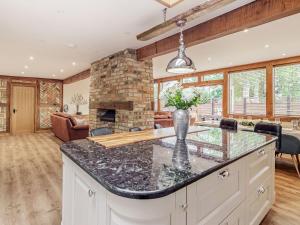 a kitchen with a large island with a stone fireplace at Chapel Barn in Bolnhurst