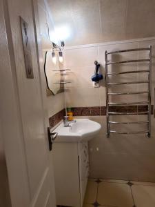 a white bathroom with a sink and a mirror at Guest house in Umanʼ