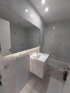 Baño blanco con lavabo y espejo en Apart Cid Campeador en Buenos Aires