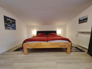 1 dormitorio con 1 cama grande con almohadas rojas en Ferienwohnungen Paar, en Schönau am Königssee