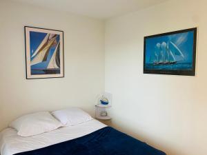 - une chambre avec un lit et une télévision murale dans l'établissement Charmant Studio Front de Mer, à Cabourg