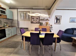 a kitchen and dining room with a table and purple chairs at Villa Radić in Makarska