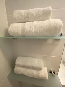 - deux empilements de serviettes sur une étagère dans une salle de bains dans l'établissement Charmant Studio Front de Mer, à Cabourg