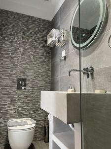 een badkamer met een wastafel, een toilet en een spiegel bij Joanna Apartments in Charaki