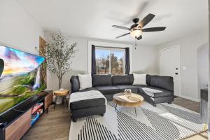 een woonkamer met een bank en een flatscreen-tv bij Peaceful Home w/ 4BR, Big Yard and amazing art in Denver