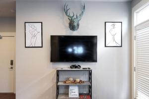 a flat screen tv on a wall with three framed pictures at Pet Friendly! Themed, Great Location! Free Pkng! in Nashville