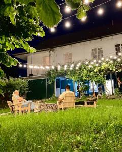 two people sitting in chairs in a yard at night at Debatoun in Debed