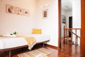 a bedroom with two beds and a staircase at Casa da Horta Açores in Ponta Delgada