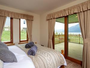 een slaapkamer met een bed en een balkon bij Skye Fall in Letterfinlay