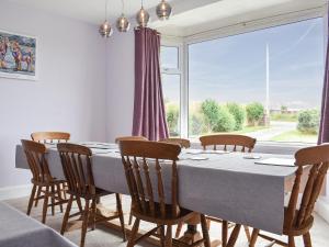 a dining room with a table and chairs and a large window at Delmonte in Langwathby