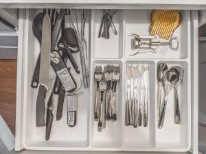 a white drawer with utensils in it at Residential Hotels Kallio in Helsinki