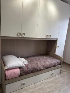 a bed in a room with white cabinets at Affitti Brevi Elmas in Elmas