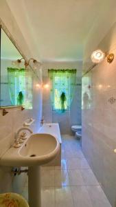 un bagno bianco con lavandino e vasca di Villetta a schiera con giardino - Val Trebbia 