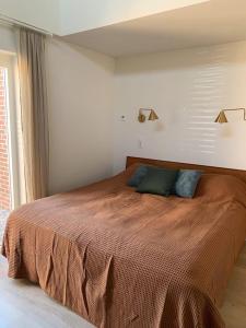 a bedroom with a large bed with a brown blanket at Guest room with terrace at the Wadden Sea in Oosterend