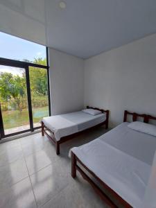 - 2 lits dans une chambre avec une grande fenêtre dans l'établissement Emuná Campestre, à Carmen de Apicalá
