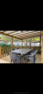 einen Tisch und Stühle auf einer Holzterrasse in der Unterkunft MOBIL-HOME NEUF 2021 3CH 34 M2 in Saint-Cyprien