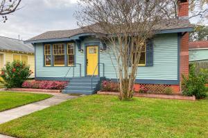 una casa blu con una porta gialla in un cortile di Gulfside in Galveston a Galveston