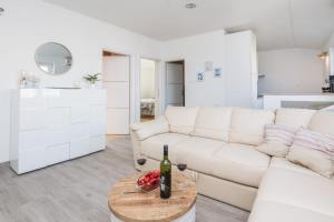 a white living room with a white couch and a table at APARTMAN SANDRA in Vir