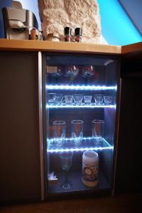 a refrigerator with wine glasses and a cup in it at Ferienwohnung Ambiente in Gaggenau