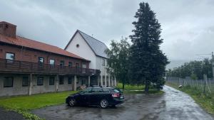 ein schwarzes Auto, das vor einem Haus parkt in der Unterkunft Sjømannskirken Narvik in Narvik