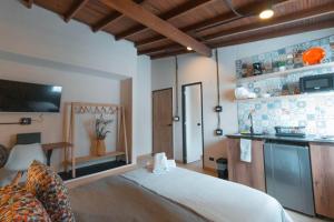 um quarto com uma cama branca e uma cozinha em NID205 Apto en Laureles para sentirse cómo en casa em Medellín