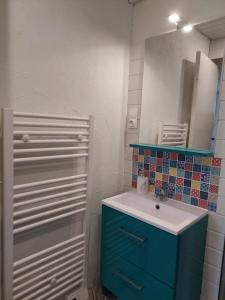 a bathroom with a blue cabinet and a sink at HAUT JURA 