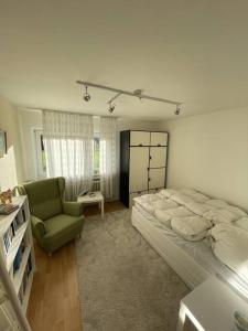 Apartment Isenbügel / Essen-Kettwig في هايليغينهاوس: غرفة نوم بسرير كبير وكرسي أخضر