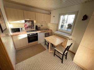 una pequeña cocina con una mesa de madera y una ventana en Apartment Isenbügel / Essen-Kettwig, en Heiligenhaus