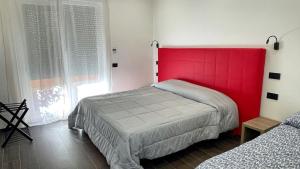 1 Schlafzimmer mit einem roten Kopfteil und 2 Betten in der Unterkunft ROMA IS ALWAYS a GOOD IDEA in Rom