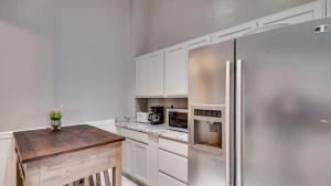 a kitchen with a stainless steel refrigerator and a table at Elegant 2 bed directly on Forsyth Park in Savannah