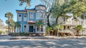 een blauw huis met palmbomen ervoor bij Elegant 2 bed directly on Forsyth Park in Savannah