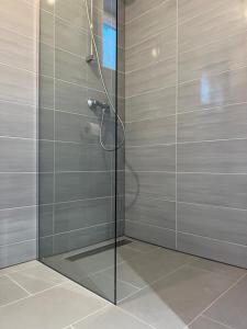 um chuveiro com uma porta de vidro na casa de banho em Boutique Hotel Tomić em Lopud