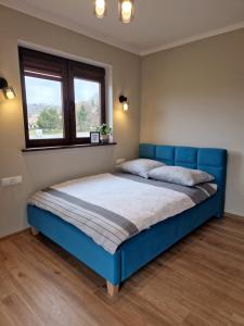 a blue bed in a bedroom with a window at Solina Bóbrka Apartamenty PanDamazy z widokiem na kamieniołom i Zalew Myczkowiecki in Solina
