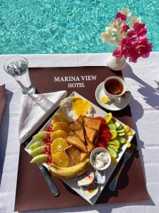 a tray of breakfast food on a table next to a pool at Marina view port ghalib in Port Ghalib