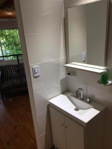 Baño blanco con lavabo y espejo en Departamento en San Rafael en San Rafael