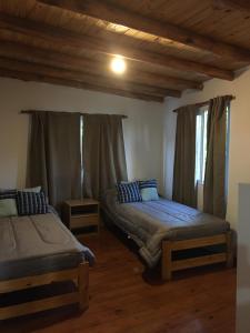 1 dormitorio con 2 camas individuales y techo de madera en Departamento en San Rafael en San Rafael
