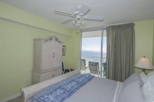 a bedroom with a bed with a ceiling fan and a balcony at Beach Club C1001 Amazing Corner Unit in Gulf Shores +44 photos