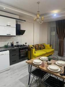 sala de estar con sofá amarillo y mesa en Nur-Ella House en Bornova