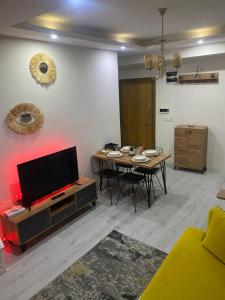 - un salon avec une table et une télévision dans l'établissement Nur-Ella House, à Burunabat