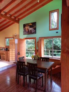 a dining room with a table and chairs and windows at MagicPlace Neis in Villarrica
